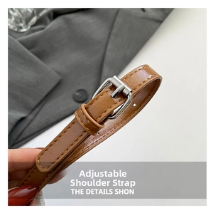 Detail of adjustable brown leather strap with silver metal buckle and neat decorative stitching
