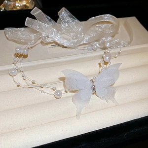 Detailed view of white organza butterfly bow with rhinestones and delicate pearls