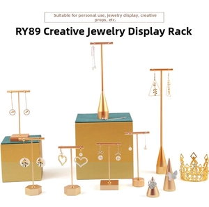 Detail of golden T-bar earring stands and conical ring holders on geometric bases