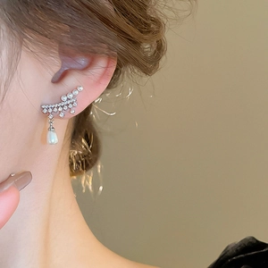 Detail view of pearl and star zircon drop earrings on model for elegant styling