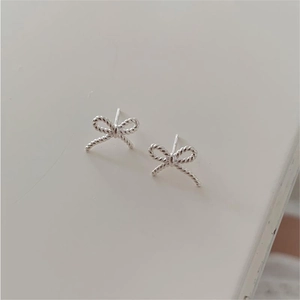 Detailed macro view of 925 sterling silver bow earrings with twisted rope texture