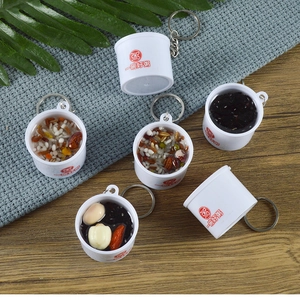 Detail view of miniature food keychains showing realistic porridge bowl models