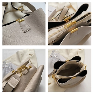 Detail of lychee pattern leather bucket bag with gold hardware and inner compartments