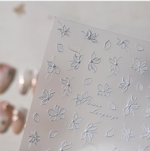 Macro detail of 5D white floral and butterfly embossed nail art stickers with Flower Language
