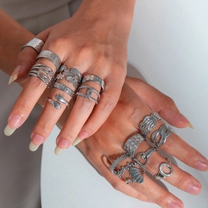 Macro shot showing diverse silver titanium steel rings with textured weave and leaf details