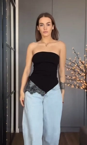 Détail du haut bustier noir avec ourlet asymétrique et bordure en dentelle fine