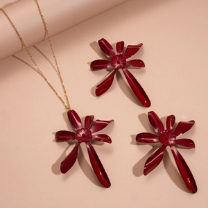 Macro shot of deep red flower jewelry set including necklace and earrings with gold chains
