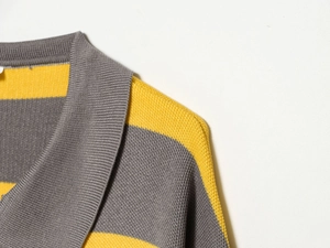 Macro shot of striped knit polo neckline with detailed gray and yellow texture