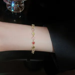 Elegant gold plated bracelet with colorful round cut cubic zirconia on a female wrist