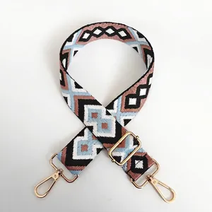 Detail showing colorful geometric diamond pattern canvas bag strap with gold metal hooks
