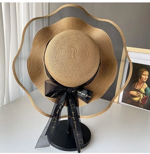 Detail of khaki straw hat with black wavy mesh edge and 'love you forever' ribbon bow