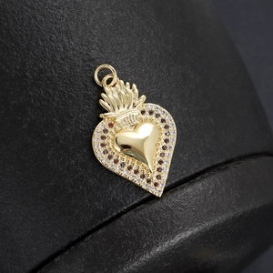 Macro shot of 18K gold-plated heart pendant with sparkling clear and dark zircon stones