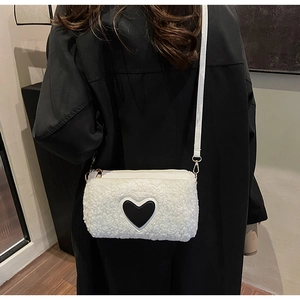 Détail du sac bandoulière blanc en faux mouton avec patch cœur et boucles dorées