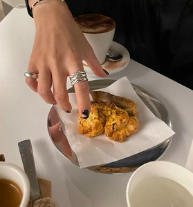 Irregular liquid metal texture silver ring worn with casual afternoon tea scene