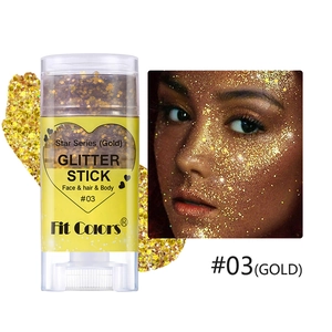 Macro detail of gold glitter stick texture and face application effect for festive makeup