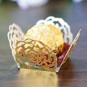 Macro view of gold hollow rose paper candy holder with a chocolate inside