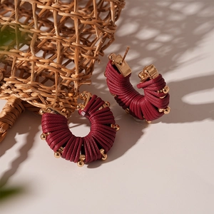 Detail of wine red faux leather wrapped U-shape earrings with gold metallic bead accents