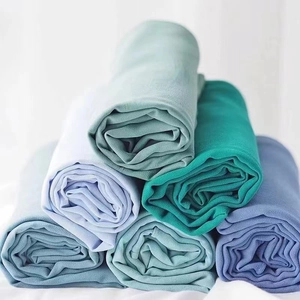 Solid pearl chiffon hijab scarves stacked in various pastel and deep blue colors