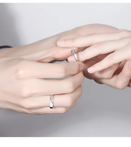 Close-up of interlocking heart couple rings in silver with micro-inlaid rhinestones