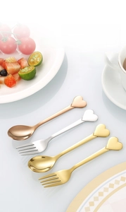 Close-up of stainless steel heart-shaped handle spoons and forks in gold, silver, and rose gold
