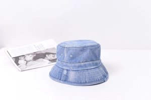 Vue détaillée d'un chapeau bob en denim bleu clair délavé avec des œillets de ventilation