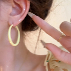 Minimalist summer cream gold hoop earrings for women shown worn on ear in warm golden finish