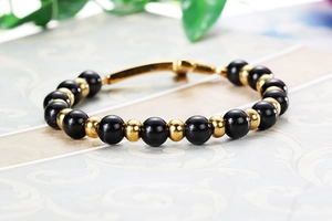 Vue détaillée des perles noires et éléments dorés sur un bracelet rétro chic