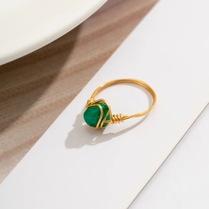 Detail of handmade gold wire-wrapped ring featuring an irregular green gemstone