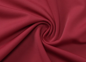 Gros plan du tissu en maille rouge foncé montrant la texture fine et l'élasticité du top