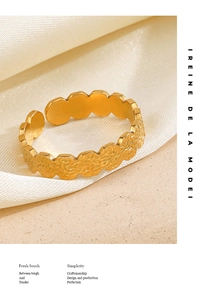 Close-up of golden geometric ring with hammered texture on elegant silk background
