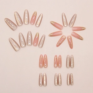 Detail of almond-shaped press on nails featuring champagne cat eye and 3D gold accents