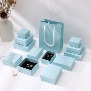 Detail of light blue jewelry packaging set with rings, necklaces and matching gift bags
