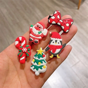 Set of 5 Christmas silicone hair clips including Santa, penguin and tree shown on a hand