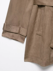 Detail of brown faux suede trench coat showing buckle cuff, side pocket and stitching