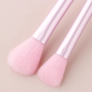 Close-up of pink makeup brushes with soft bristles and metallic crystal handles