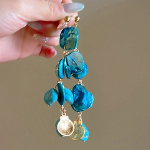 Boho oorbellen met blauwe schelplagen en goudkleurige zeeschelp bedeltjes