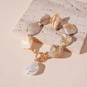Detail of shell beaded necklace with gold chain, OT clasp and teardrop pearl pendant