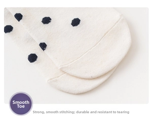 Macro detail of reinforced flat seam on cream socks with black polka dots for durability