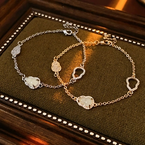 Macro shot of gold and silver hollow gourd bracelets with zircon on velvet display