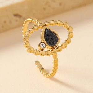 Detail of gold beaded adjustable ring with teardrop blue stone and small zircon accent