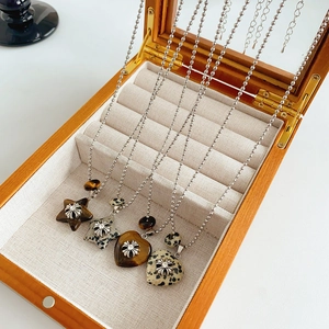 Detail of heart and star pendants with natural stone inlay on beaded necklaces