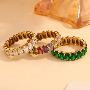 Three gold rings with oval-cut crystals in clear, multicolor, and green gemstones