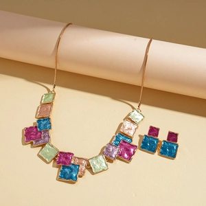 Detail of colorful geometric enamel necklace and earring set with square patchwork pattern