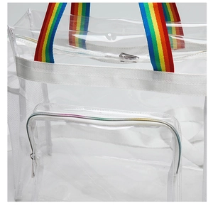 Close-up of clear PVC beach bag featuring vibrant rainbow straps and front zipper pocket