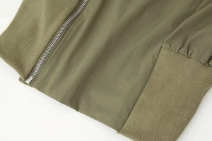 Détail macro de la veste vert militaire avec fermeture éclair et poignets côtelés