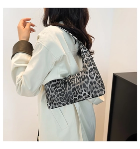 Close-up of leopard print bucket bag worn on the shoulder with stylish side view detail
