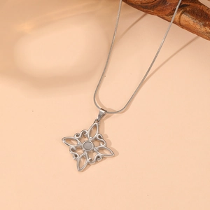 Detail shot of silver Celtic knot pendant with centered gray gemstone and snake chain