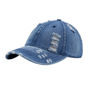 Distressed blue washed denim baseball cap with vintage frayed holes and curved brim