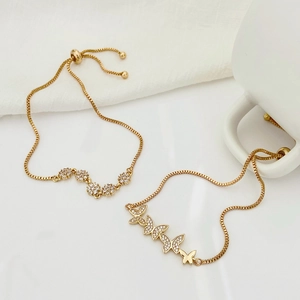 Detail of gold floral and butterfly zircon bracelets with adjustable sliding closures