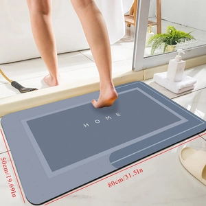 Detail view of 80x50cm grey diatomite bath mat with white HOME text and anti-slip texture